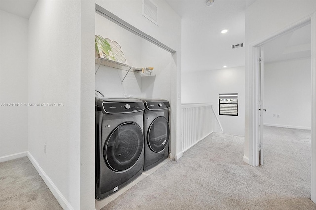 clothes washing area featuring separate washer and dryer and light colored carpet