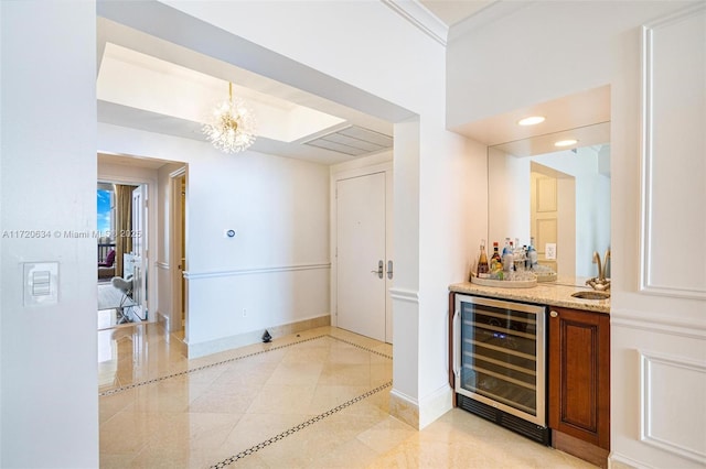 bar with a sink, wine cooler, baseboards, indoor bar, and a chandelier