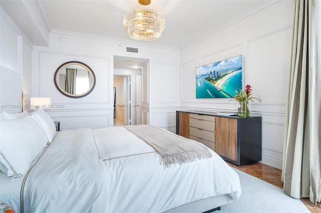 bedroom featuring a decorative wall, an inviting chandelier, visible vents, and ornamental molding