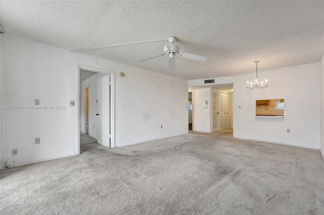 carpeted empty room with ceiling fan with notable chandelier and a textured ceiling