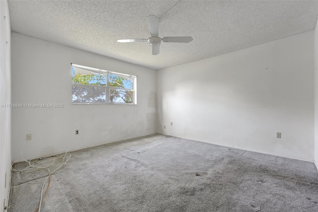 carpeted empty room with ceiling fan and a textured ceiling