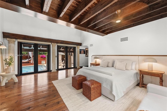 bedroom featuring visible vents, beamed ceiling, wood finished floors, access to outside, and french doors