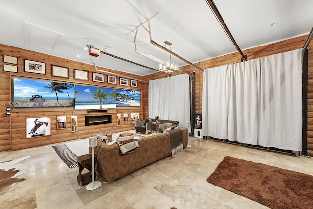 living area with a glass covered fireplace and wood walls