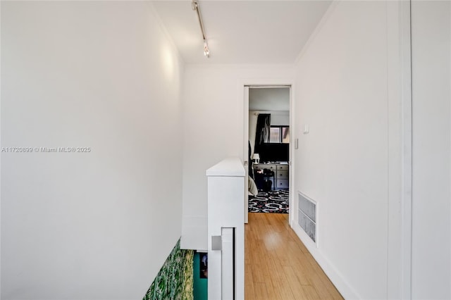 hall with track lighting and light hardwood / wood-style flooring