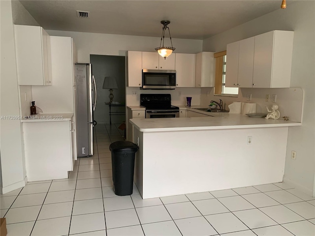 kitchen with kitchen peninsula, stainless steel appliances, sink, light tile patterned floors, and hanging light fixtures