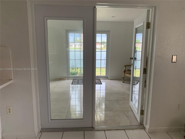 doorway to outside with baseboards and light tile patterned floors