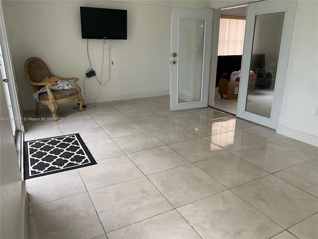 interior space featuring light tile patterned flooring and baseboards
