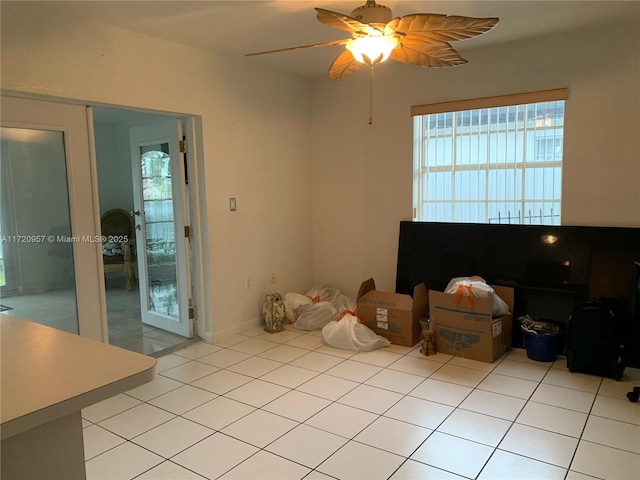 interior space with light tile patterned floors and a ceiling fan