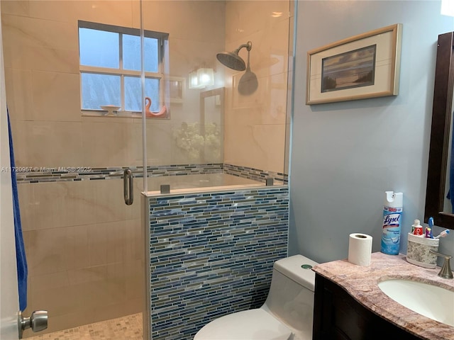 bathroom featuring vanity, toilet, and a shower with shower door