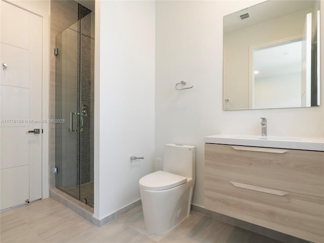 bathroom with vanity, toilet, and a shower with shower door