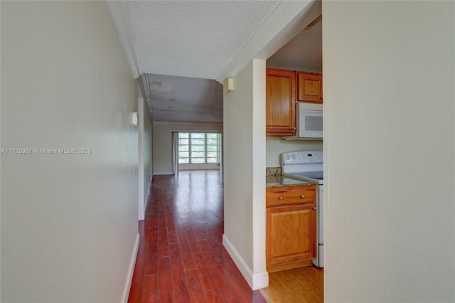 hallway with dark wood-type flooring and a textured ceiling