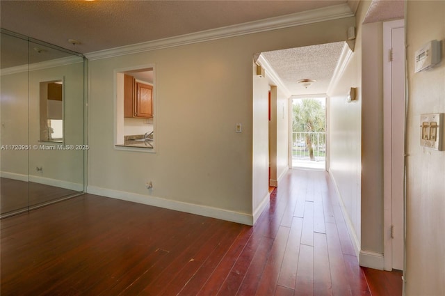 hallway featuring expansive windows, dark hardwood / wood-style floors, a textured ceiling, and ornamental molding