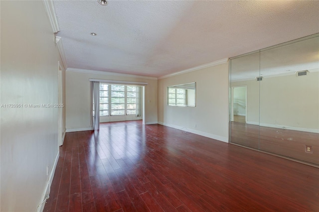 spare room featuring a textured ceiling, crown molding, and dark wood-type flooring