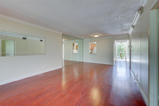 spare room featuring hardwood / wood-style flooring, ornamental molding, and a textured ceiling