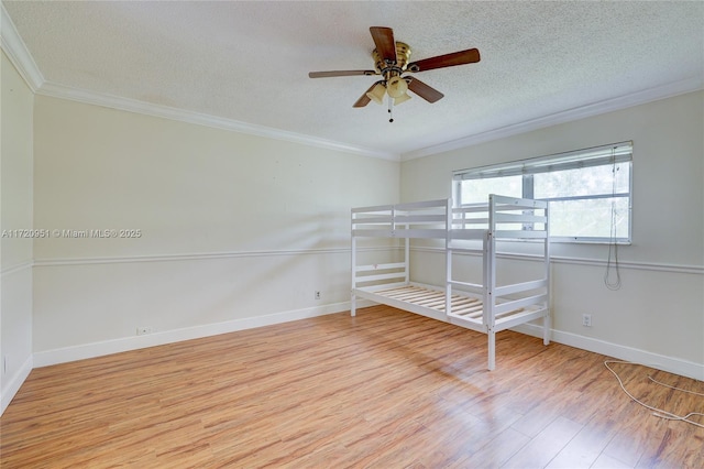 unfurnished bedroom featuring ceiling fan, crown molding, light hardwood / wood-style floors, and a textured ceiling