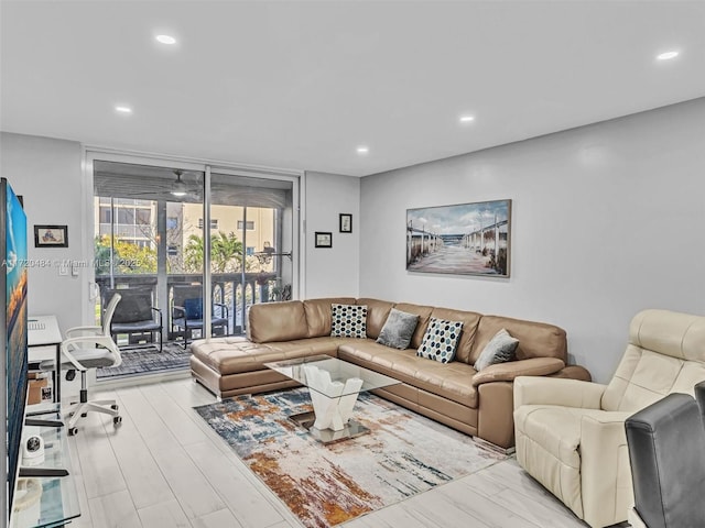 living room with a wall of windows and light wood-type flooring