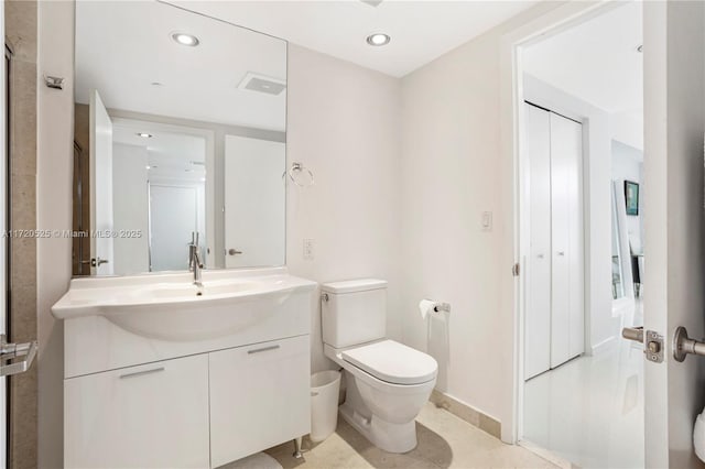 bathroom with tile patterned flooring, vanity, and toilet