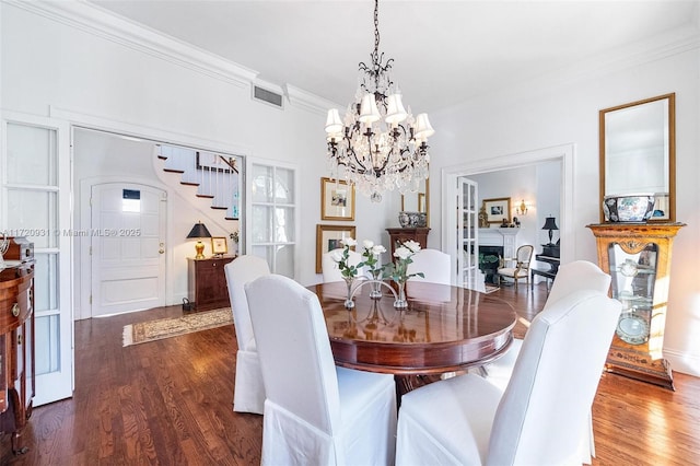 dining area featuring a chandelier, dark hardwood / wood-style flooring, and crown molding