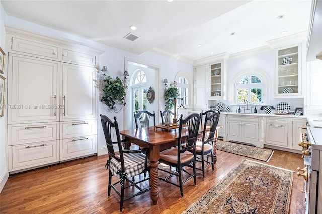 dining space featuring crown molding, sink, and wood-type flooring