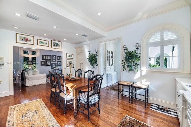 dining space with crown molding and dark hardwood / wood-style floors