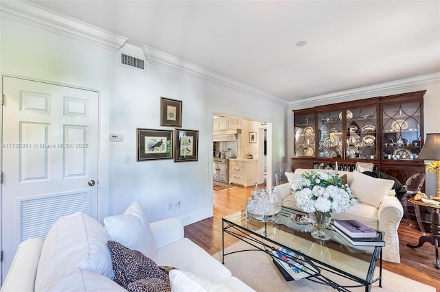 living room with wood-type flooring and ornamental molding