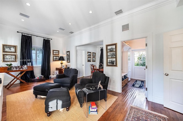 living room with wood-type flooring and crown molding