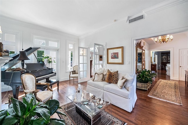 living room featuring a notable chandelier, dark hardwood / wood-style floors, and ornamental molding