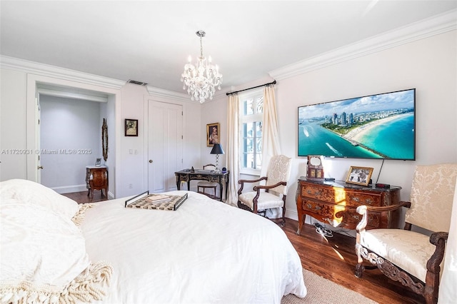 bedroom with a chandelier, crown molding, and wood-type flooring