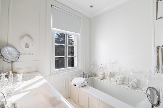 bathroom with a tub to relax in, ornamental molding, and sink