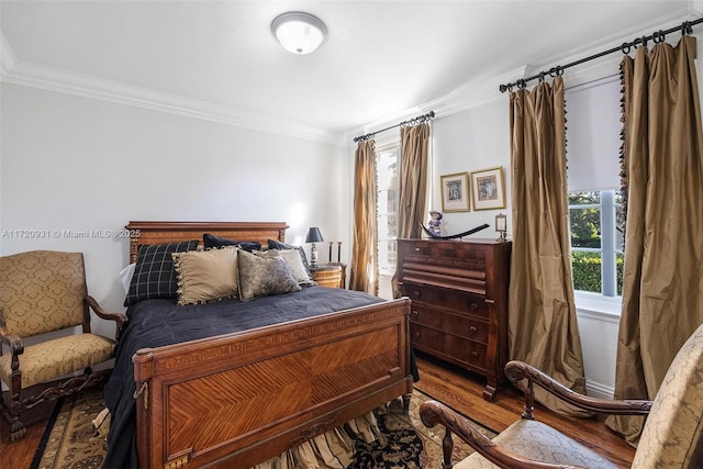 bedroom featuring ornamental molding and hardwood / wood-style flooring