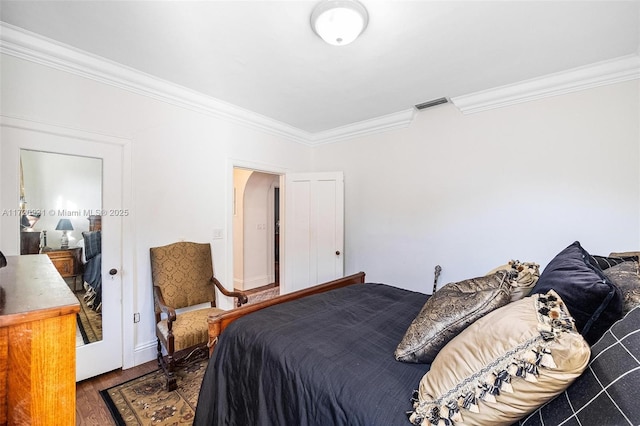 bedroom with dark hardwood / wood-style flooring and crown molding