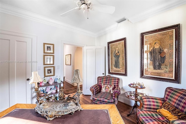 living area with ceiling fan, wood-type flooring, and ornamental molding