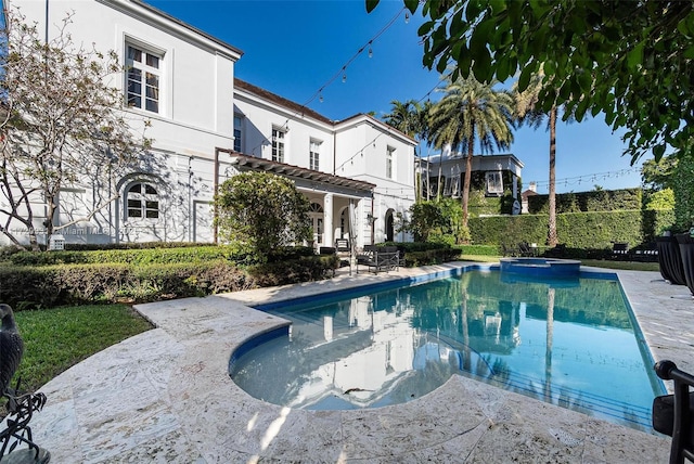 view of pool featuring a patio area and an in ground hot tub