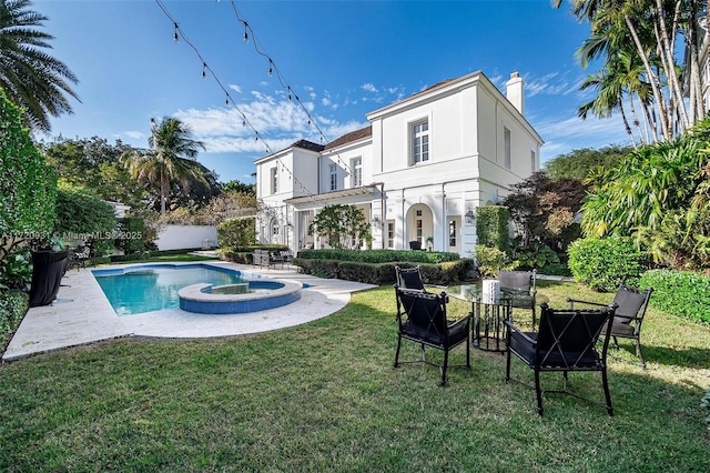 view of swimming pool featuring an in ground hot tub and a lawn