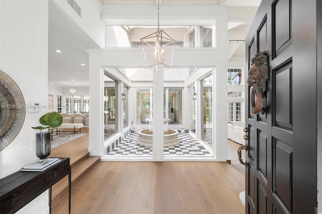 entrance foyer with a notable chandelier and light hardwood / wood-style floors