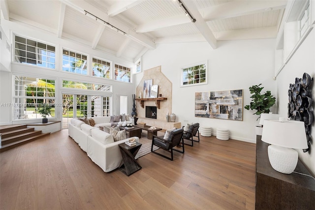 living room featuring french doors, track lighting, high vaulted ceiling, beamed ceiling, and hardwood / wood-style floors