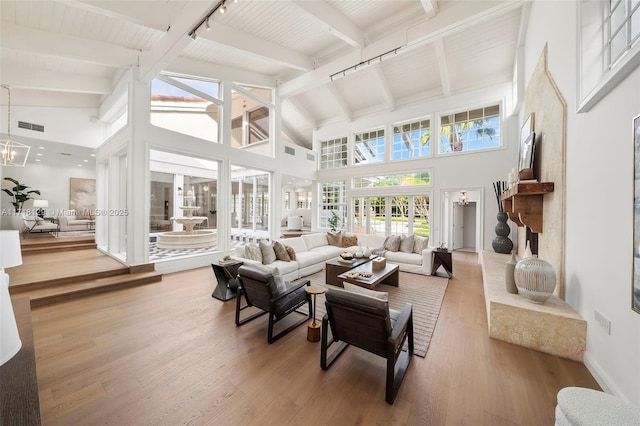 living room featuring beamed ceiling, hardwood / wood-style floors, high vaulted ceiling, and track lighting