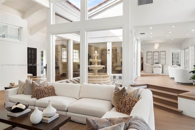 living room featuring beamed ceiling, high vaulted ceiling, and light hardwood / wood-style flooring