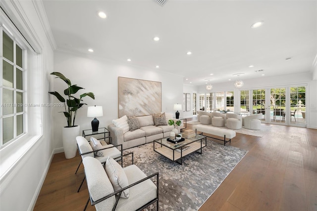 living room with hardwood / wood-style flooring, crown molding, and french doors