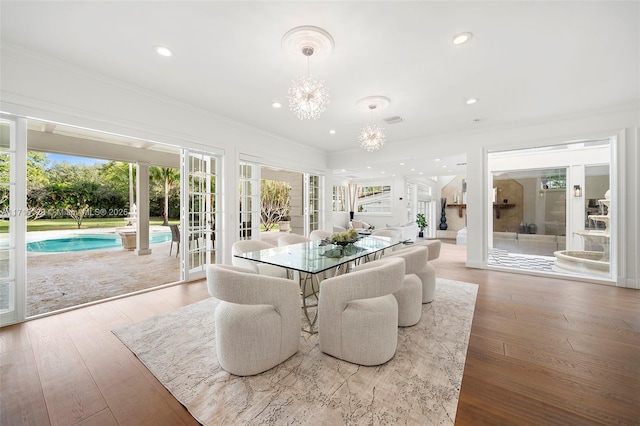 dining room featuring hardwood / wood-style flooring, crown molding, a wealth of natural light, and french doors