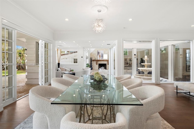 dining area with crown molding, french doors, dark wood-type flooring, and an inviting chandelier