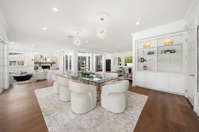 dining room with dark hardwood / wood-style floors, crown molding, and an inviting chandelier