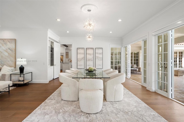 dining space featuring hardwood / wood-style flooring, an inviting chandelier, and ornamental molding