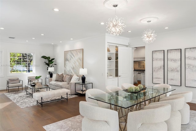 dining space with crown molding, a notable chandelier, and hardwood / wood-style flooring