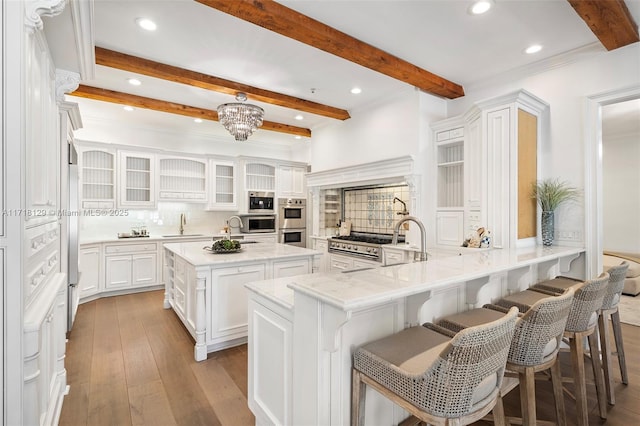 kitchen with white cabinetry, a center island, tasteful backsplash, kitchen peninsula, and a kitchen bar