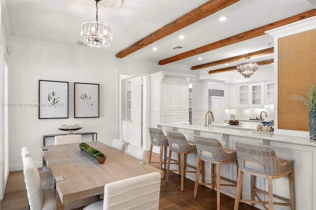 dining room featuring a chandelier, dark hardwood / wood-style flooring, beamed ceiling, and sink