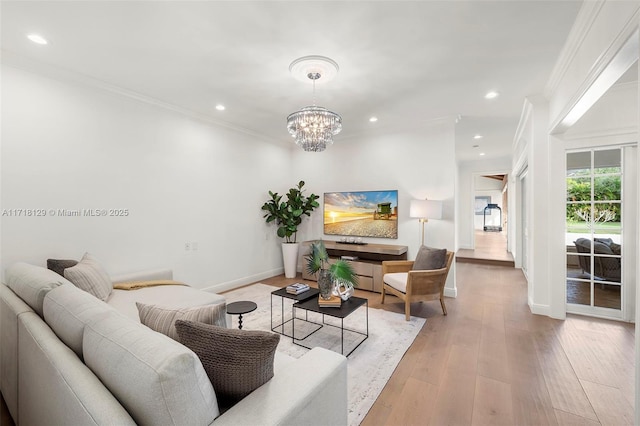 living room featuring light hardwood / wood-style floors, crown molding, and an inviting chandelier