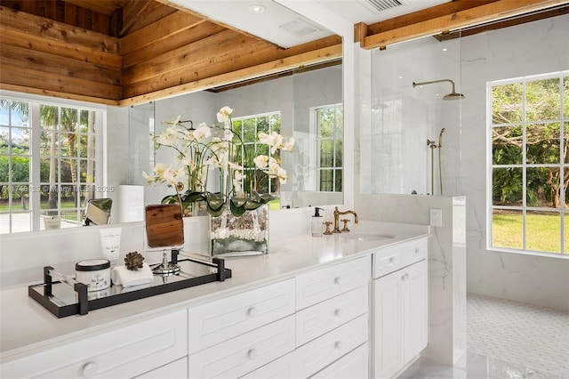 interior space with vanity and tiled shower