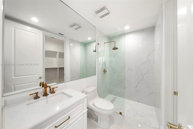 bathroom with toilet, vanity, and tiled shower