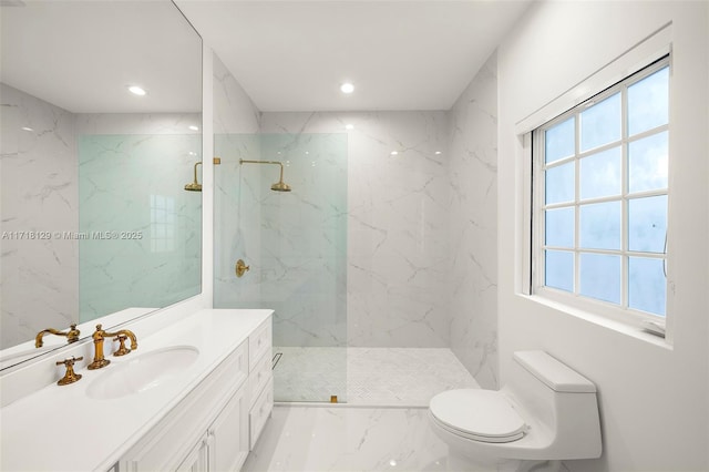 bathroom with a tile shower, vanity, toilet, and plenty of natural light